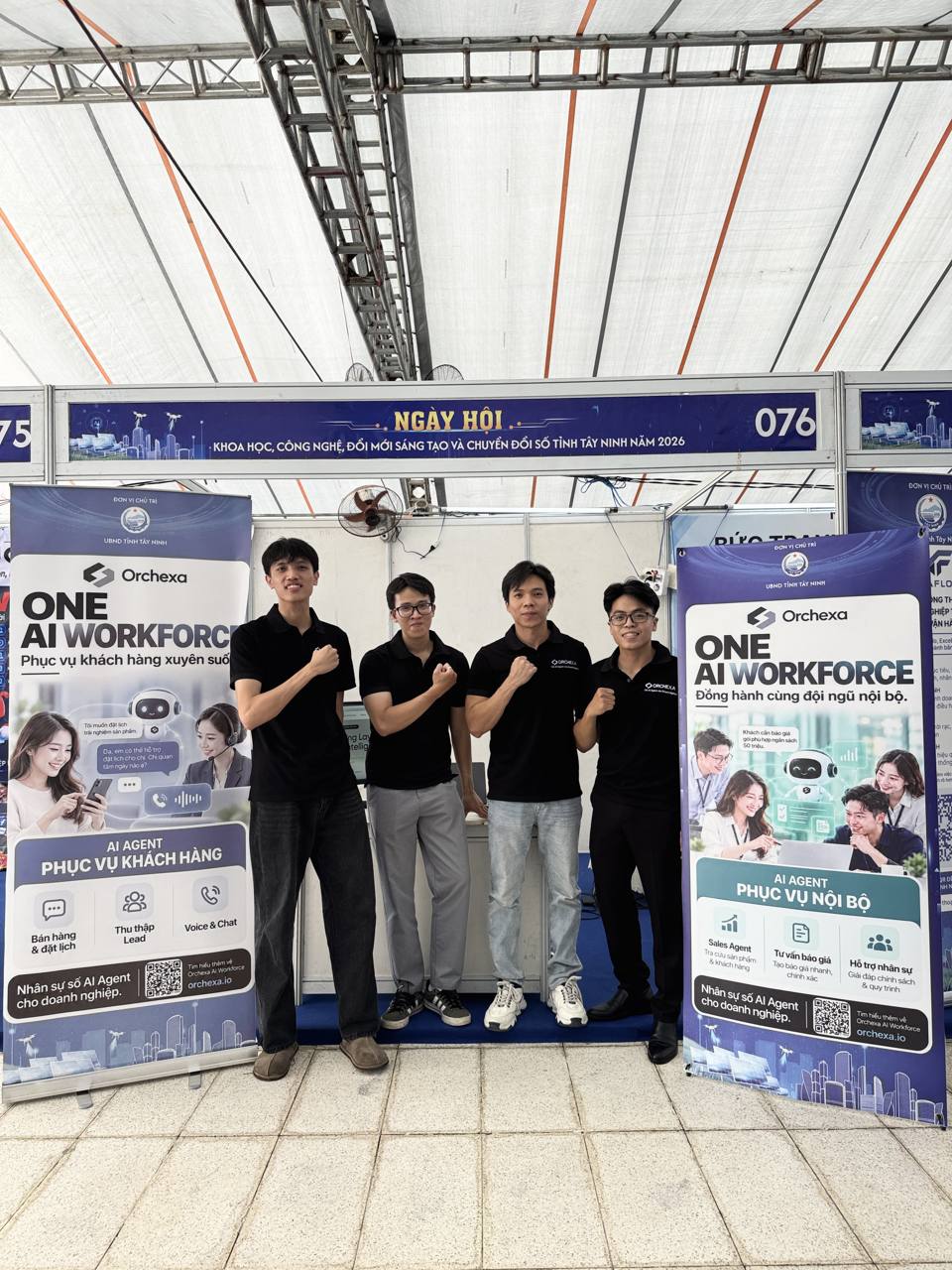 Orchexa team in front of the ONE AI WORKFORCE banners